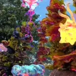 Visuals from Radiant Echoes. Colorful, moving shapes dance infront of green trees and blue skies.