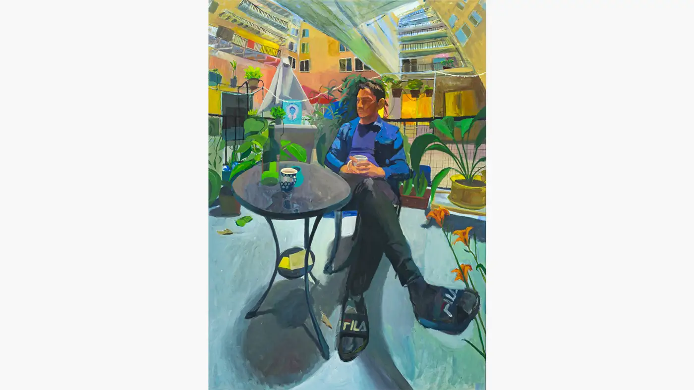 Painting of a seated figure at a small table on a plant-filled balcony, surrounded by colorful urban buildings.