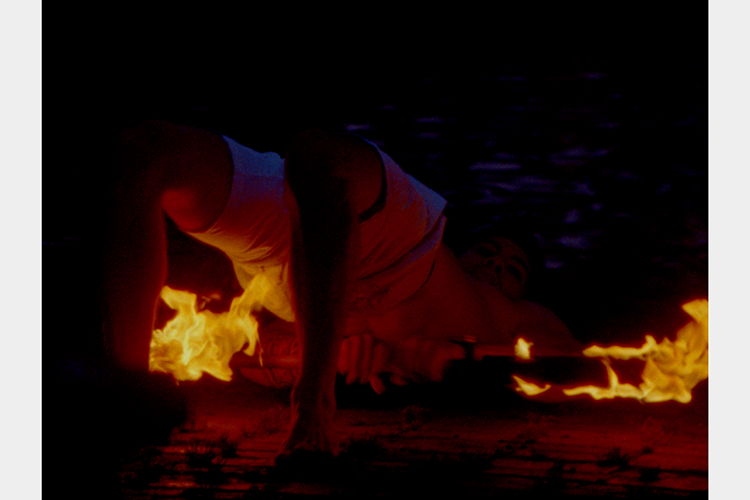 a man laying on the floor hips lifted above a burning stick a man laying on the floor hips lifted above a burning stick