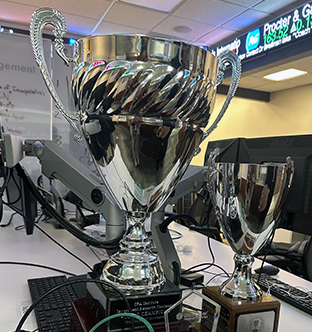 Large, silver first place trophy next to a smaller, silver trophy