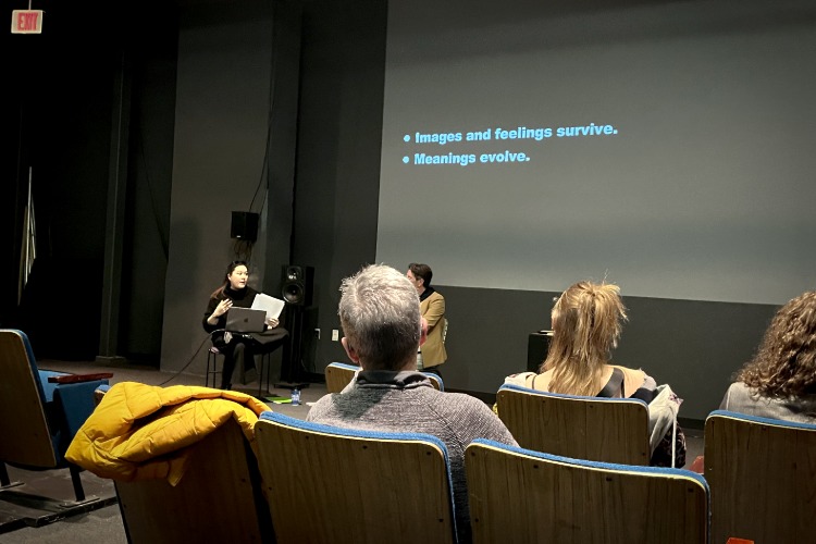 A slide projected onto a wall says "Images and feelings survive. Meanings Evolve." The presentation is part of the Language as Collaborator: Co-Creating with Thinking Machines workshop, part of C21's Aesthetics, Art, & AI program series.