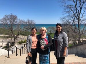 three people standing in front of a lake