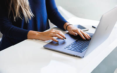 White woman typing on laptop