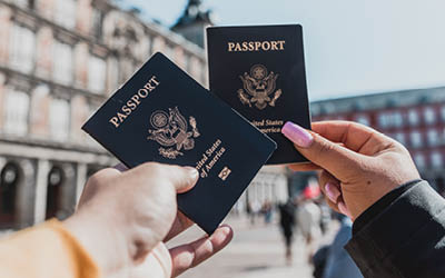 Man and woman holding up passports