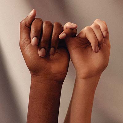 African American hand and white hand holding pinkies