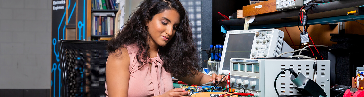 South Asian female student working with electronics