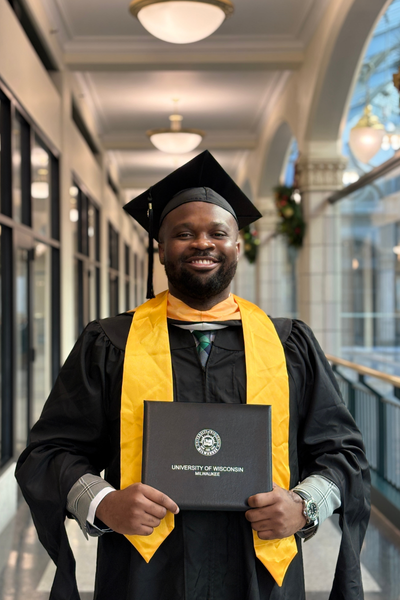 Male UWM graduate from Nigeria smiling with pride