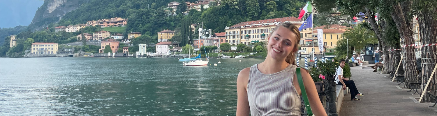 UWM student abroad in Italy in front of Italian cityscape and water