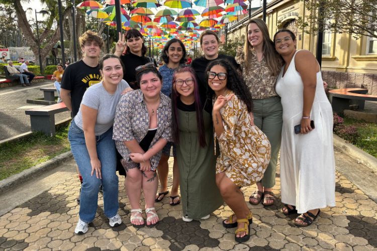 Group of UWM study abroad students in front of colorful umbrellas