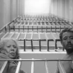 two people looking down from a balcony