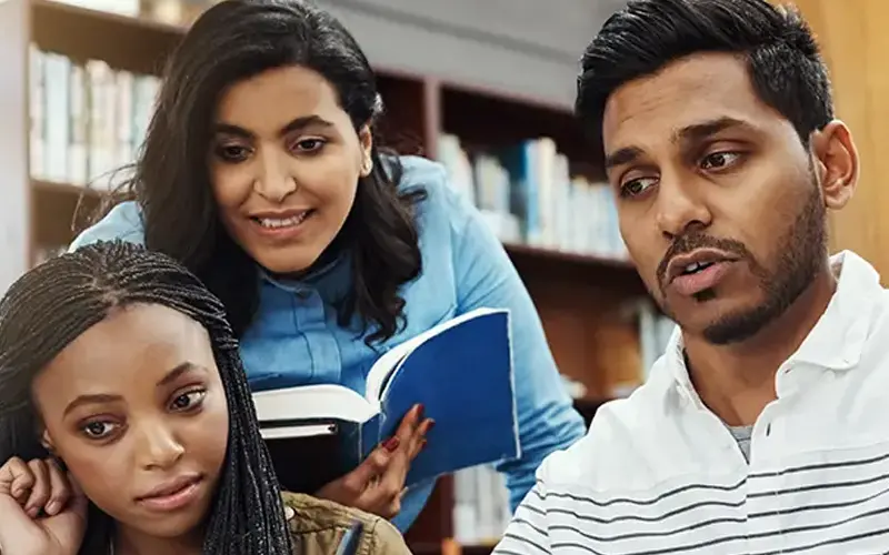 students gathered around laptop