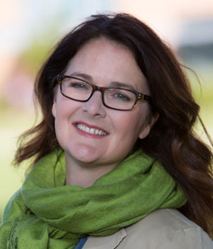 Front-facing portrait of Elizabeth Watson, smiling, with shoulder partially visible.