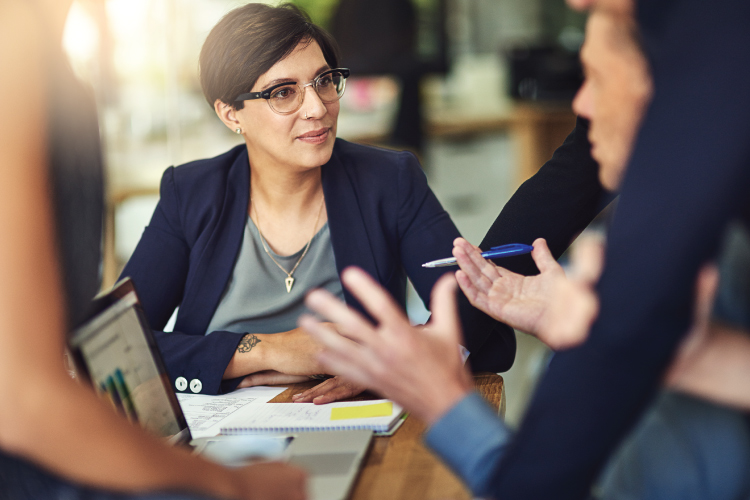 People collaborating in an office setting with data on the computer screen.