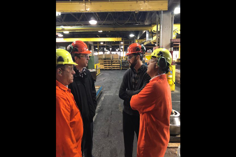 A group of men talking together at the ATI Forged Metals facility
