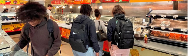 Students queueing to be served food at a dining hall