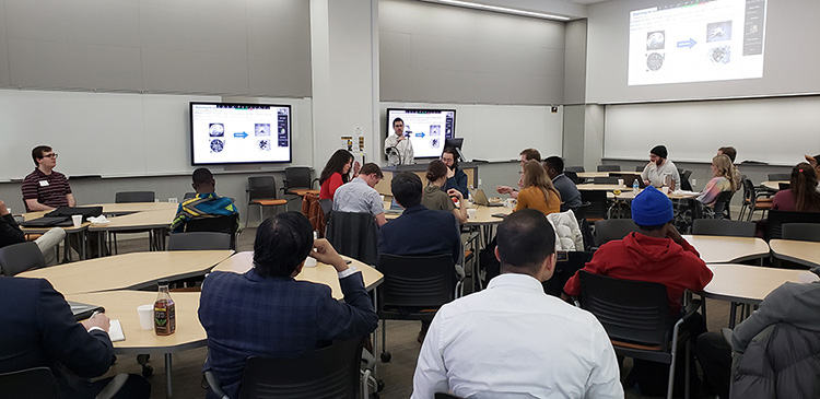 Presenter speaking to a full classroom at MIDD Symposium 2023