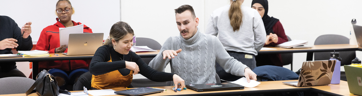 A male and female student in a conversation during a working group session