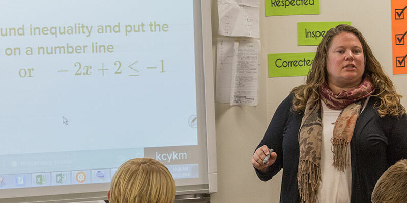 Melissa Hongsermeier working with her ninth grade algebra class at South Milwaukee High School to solve a math problem.