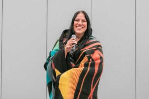 Jamie Kellicut holding microphone wrapped in gifted blanket