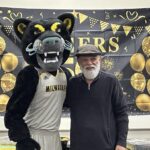 panther mascot poses with a man
