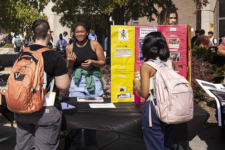 woman behind a table talking to passersby