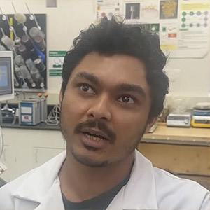 head shot of a Middle Eastern man in a white lab coat looking at the camera