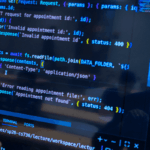 Faculty member and computer science student reviewing code on wall-mounted digital monitor.