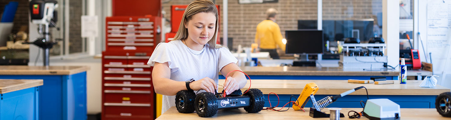 A student working on a robot car at the UWM Makerspace.