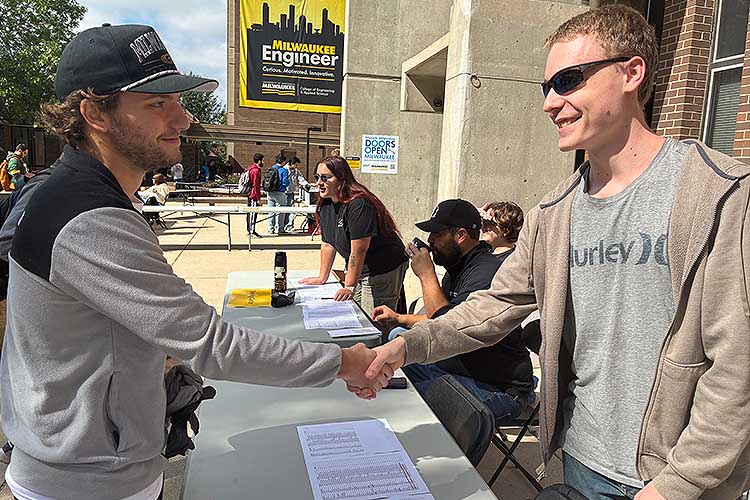 Two young men look at each other and shake hands. Two young men look at each other and shake hands.