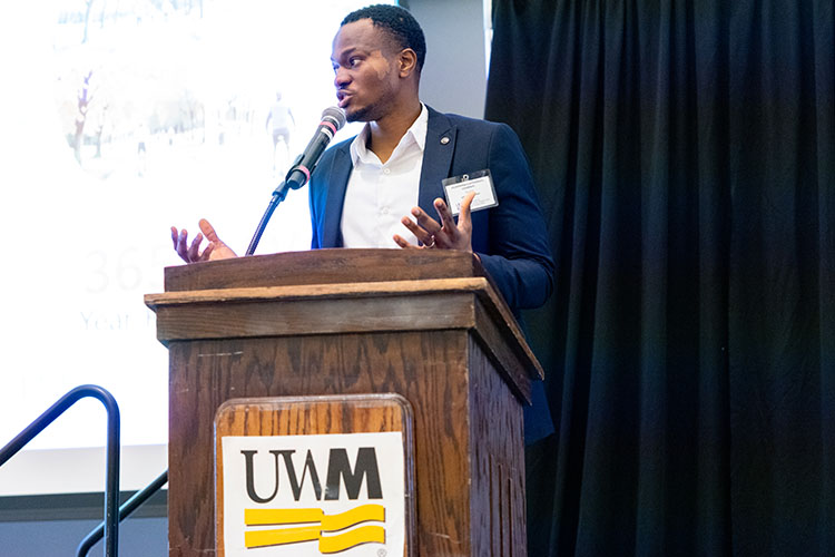 A young Black man speaks at a podium