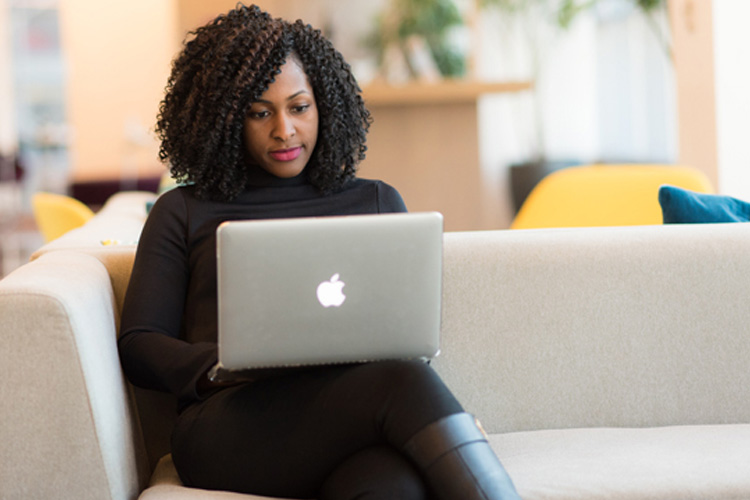person sitting on couch with laptop