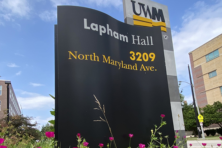 Flowers in front of a sign for Lapham Hall.
