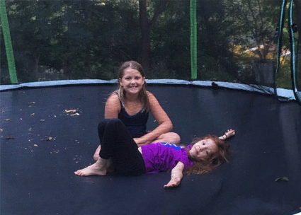 Two young girls on a trampoline