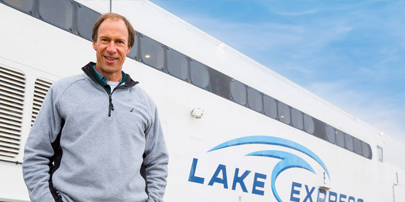 Harvey Bootsma standing next to the Lake Express boat