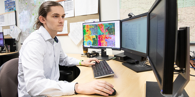 male student at computer in innovative weather office