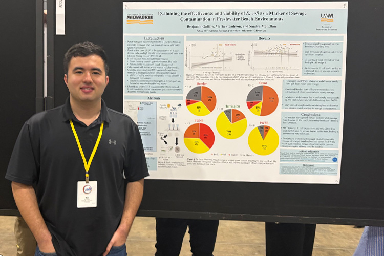 A man stands in front of a poster.