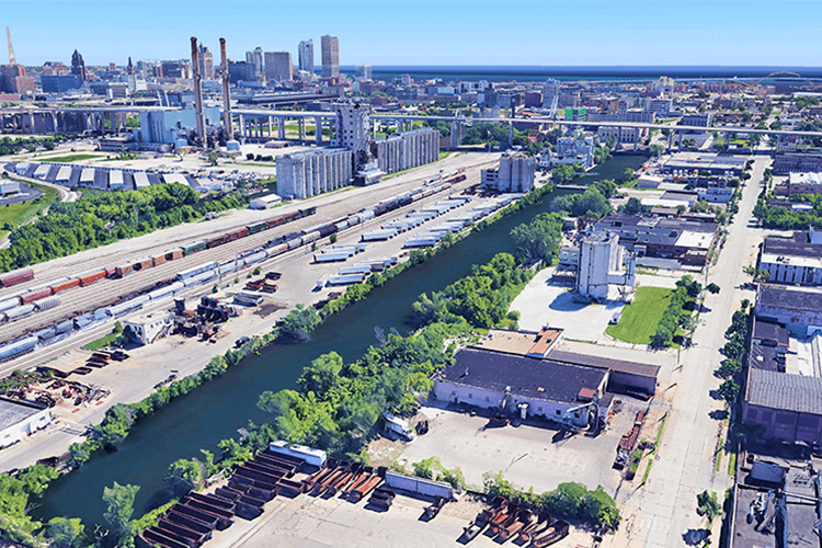 Bird's eye view of a river and canal within industrial surroundings.