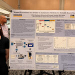 A woman is standing next to a poster.