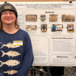 A man stands in front of a research poster.