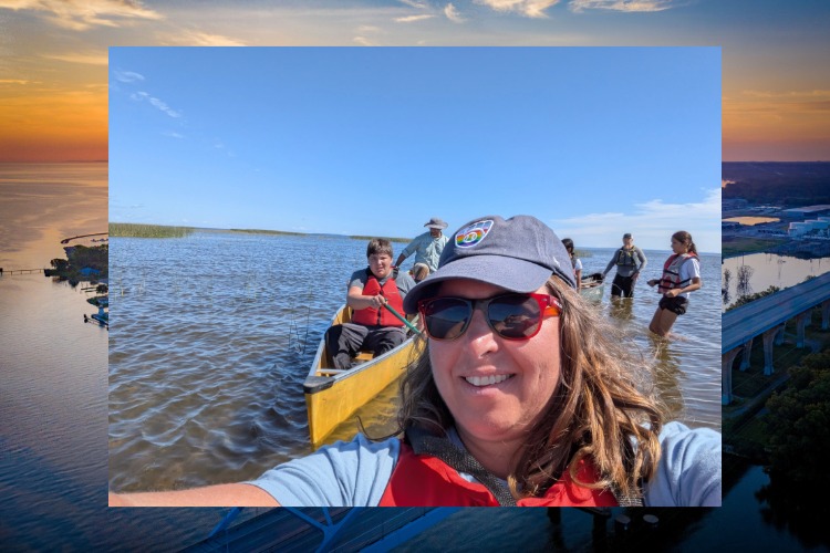 Emily Tyner on a canoe in the water with a group of students in canoes behind her.