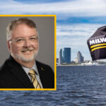 Bryan Porter smiling in front of a dark background. A skyline photo is behind the image.