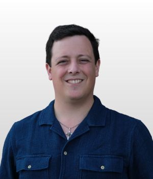 Josh Marion smiling in front of a white background.