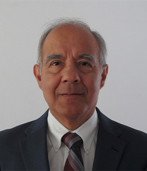 Hector Bravo in front of a gray background.
