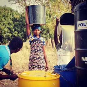 A woman in a small village in northern Ghana brings water to a filtration location.