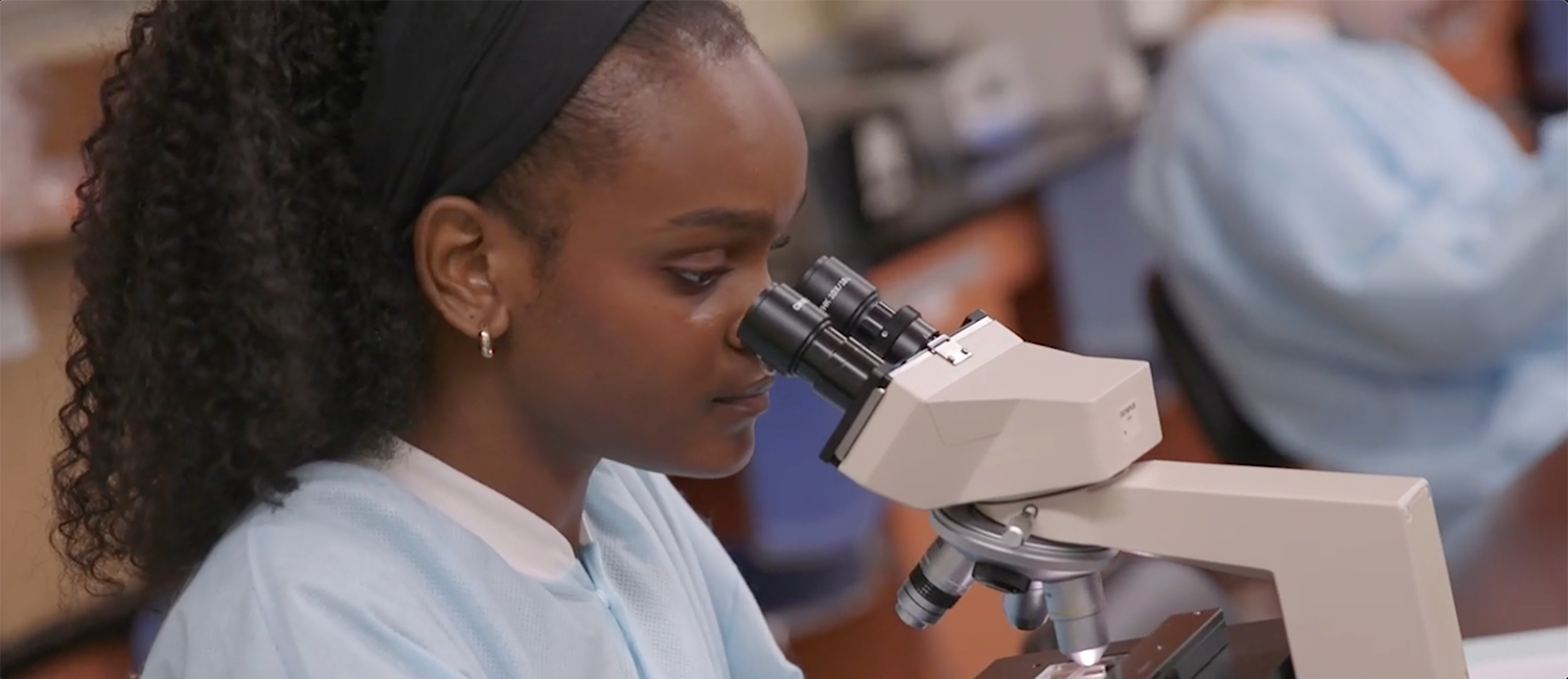 UWM health professions and sciences student using a microscope