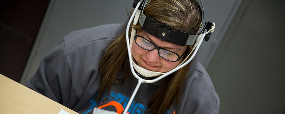 Student wearing assistive device for writing