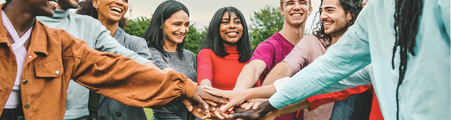 people in a circle with hands touching in the middle