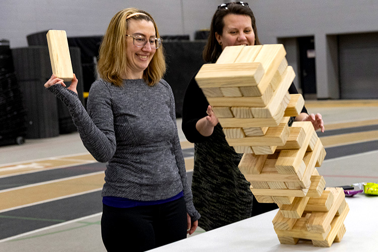 UWM employees playing a wooden block tower building game.