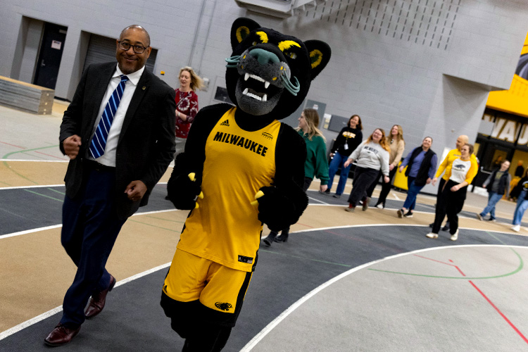 UWM Chancellor Gibson and Pounce walking at the Klotsche Center.