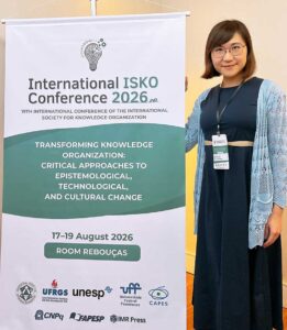 Dr. Wan-Chen Lee stands next to a banner at the International ISKO Conference 2026 in São Paulo, Brazil.